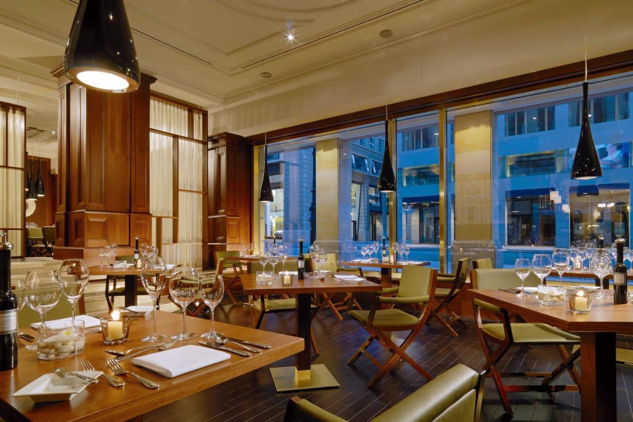 מלון The Westin Grand ברלין מראה חיצוני תמונה The photo shows an elegant restaurant interior featuring wooden furnishings and stylish decor. The space has large windows that allow natural light to enter, showcasing views of the outside. There are several tables set for dining, each equipped with